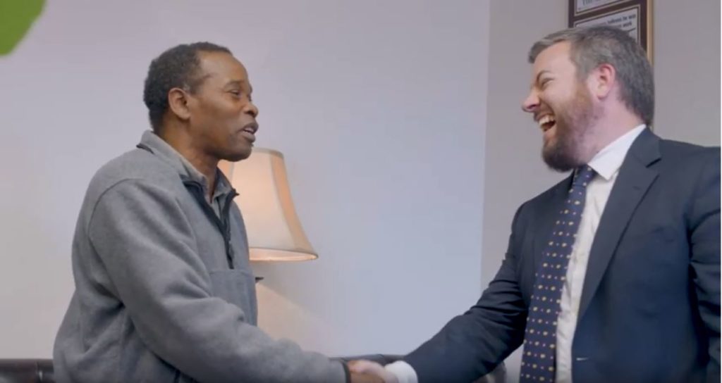 2 men laughing while shaking hands
