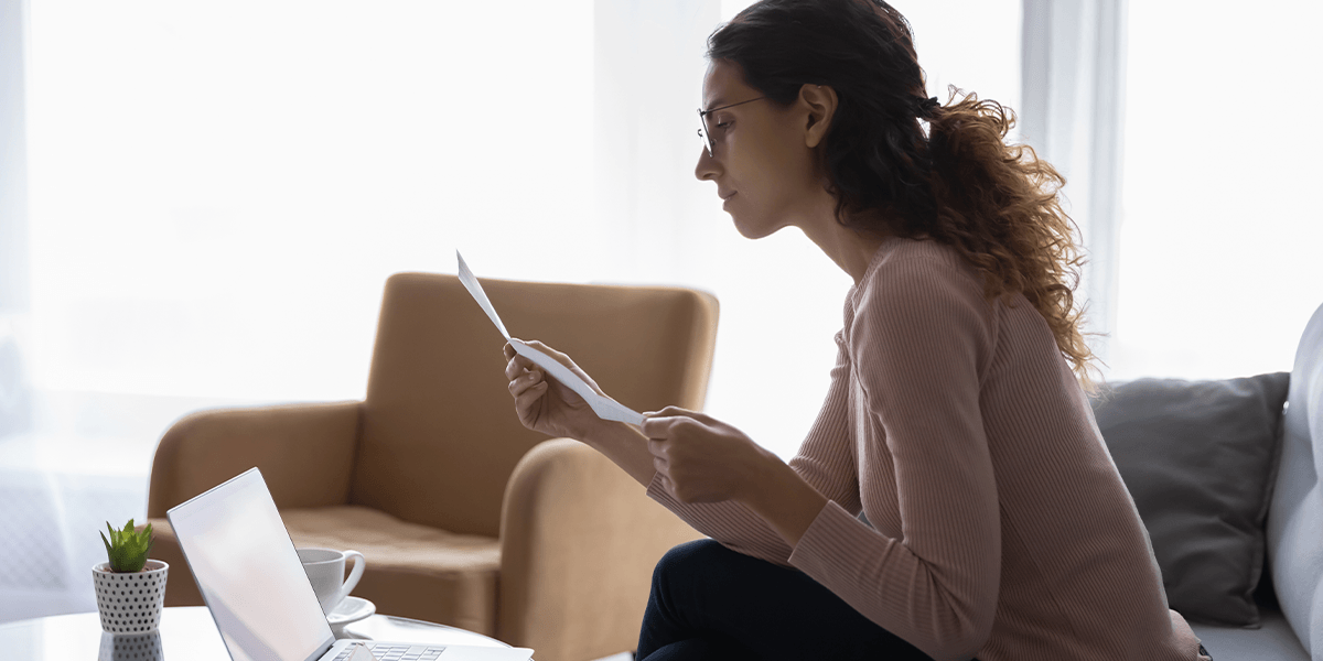 woman reading irs notice on her couch