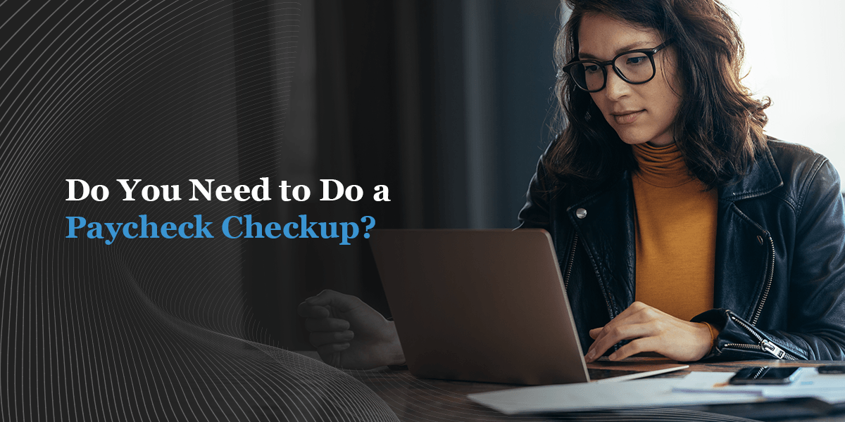 A woman sits and looks at her laptop 